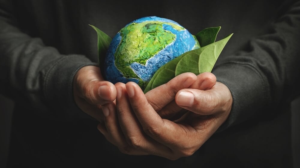 Hands holding an earth sculpture