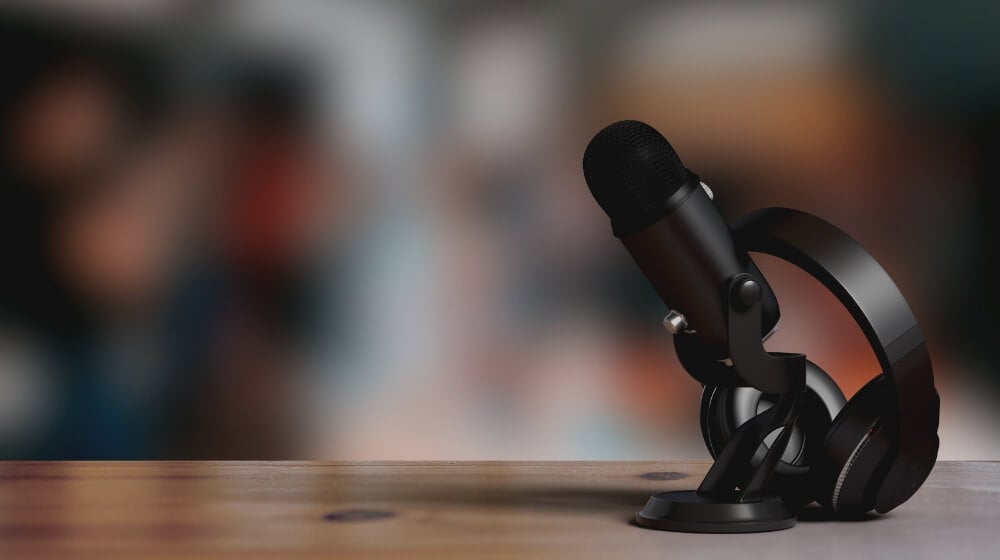 black microphone and headphones sitting on desk