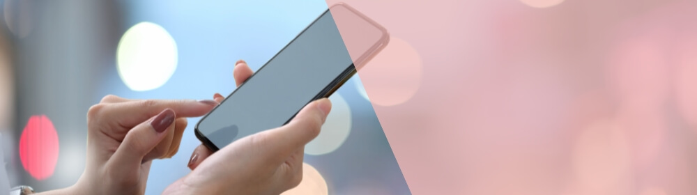 woman's hands with red nail polish holding cell phone
